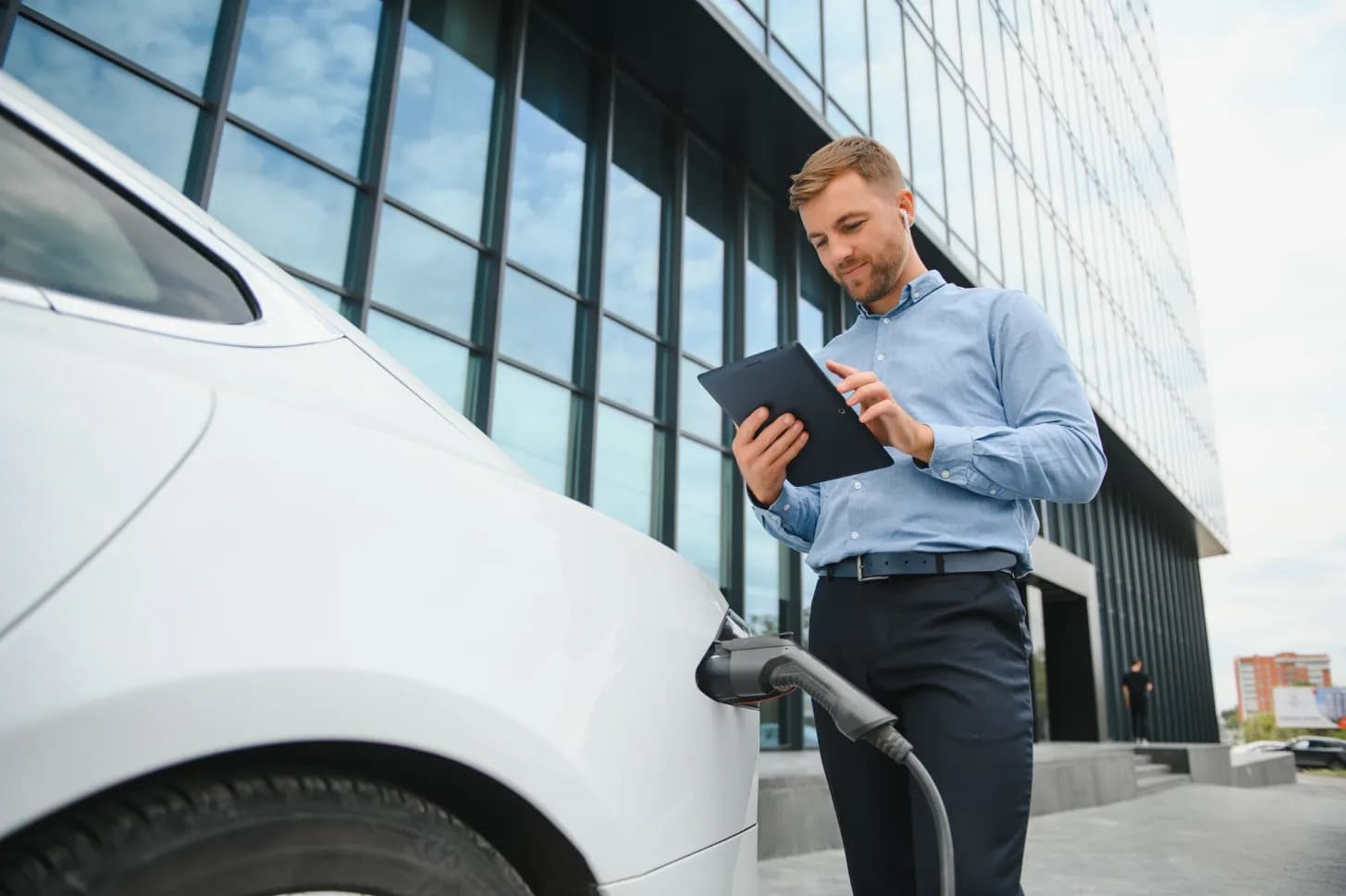 Man on tablet charging car